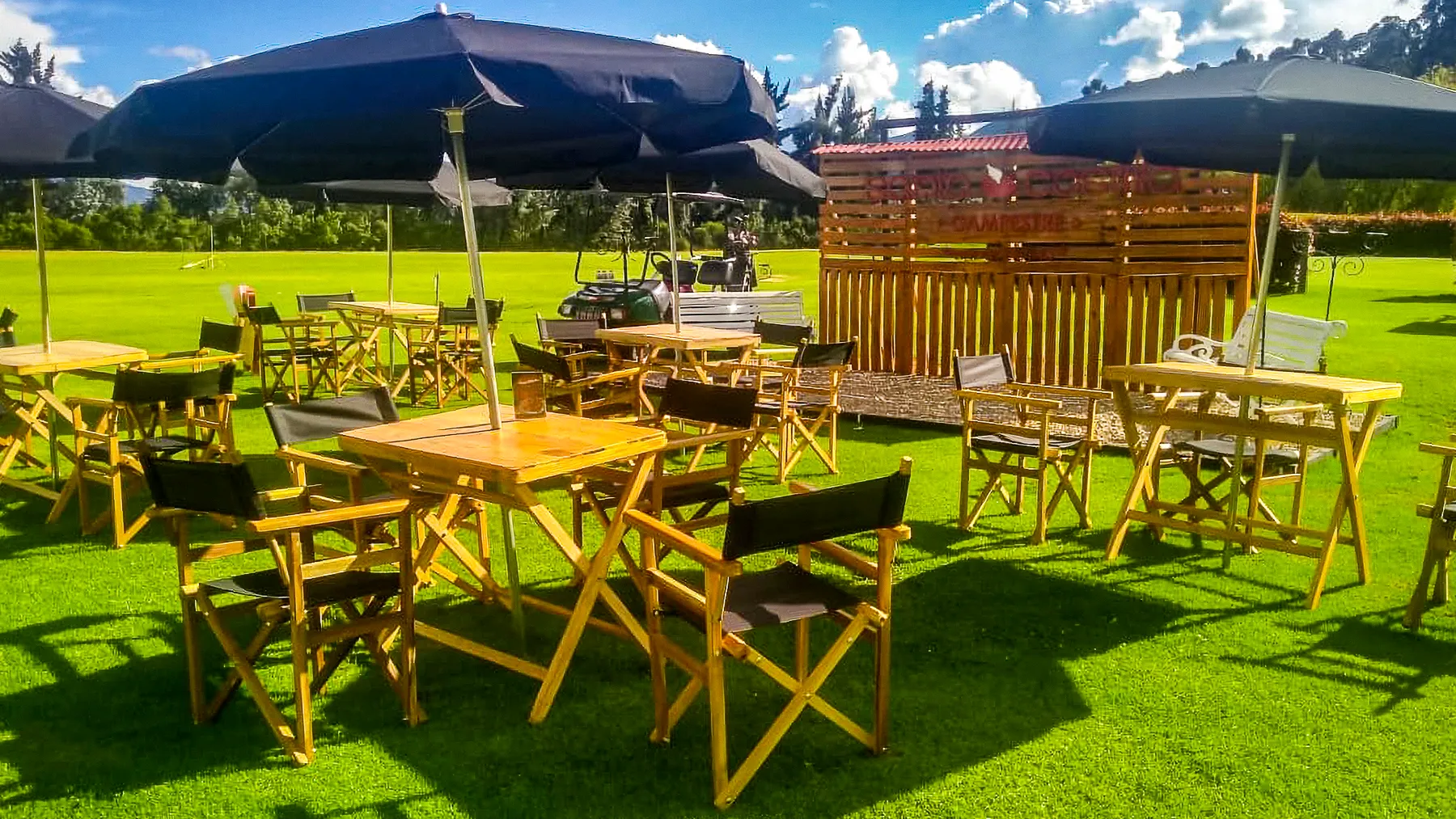 Sala rústica en estibas con cojines blancos para evento al aire libre en Bogotá